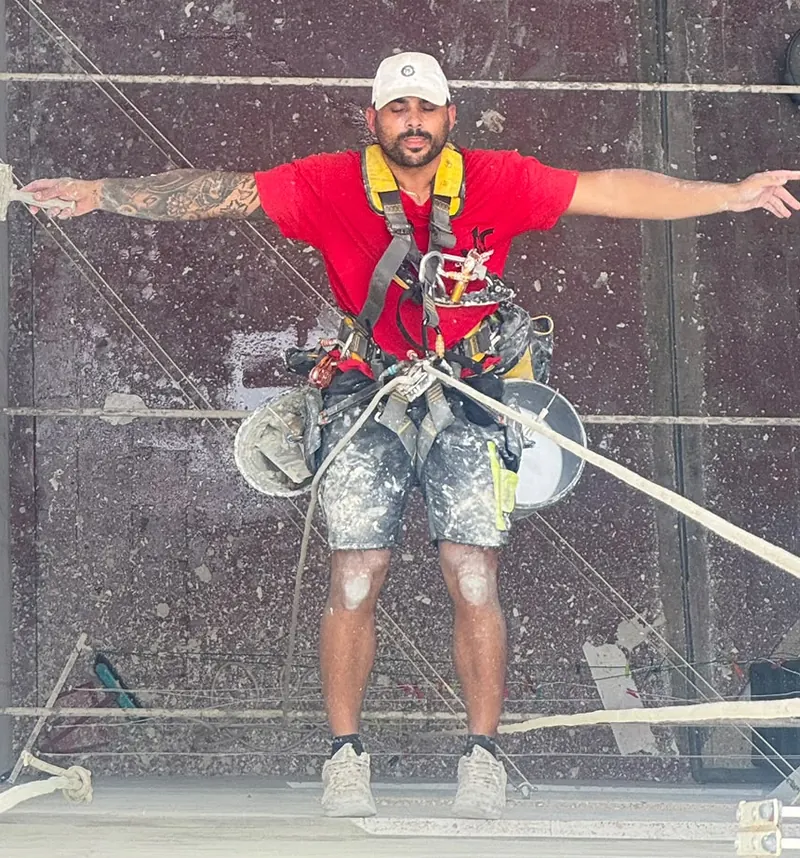Cristofer González, gerente de JC Construcciones, colgado con arnés en un patio de luces