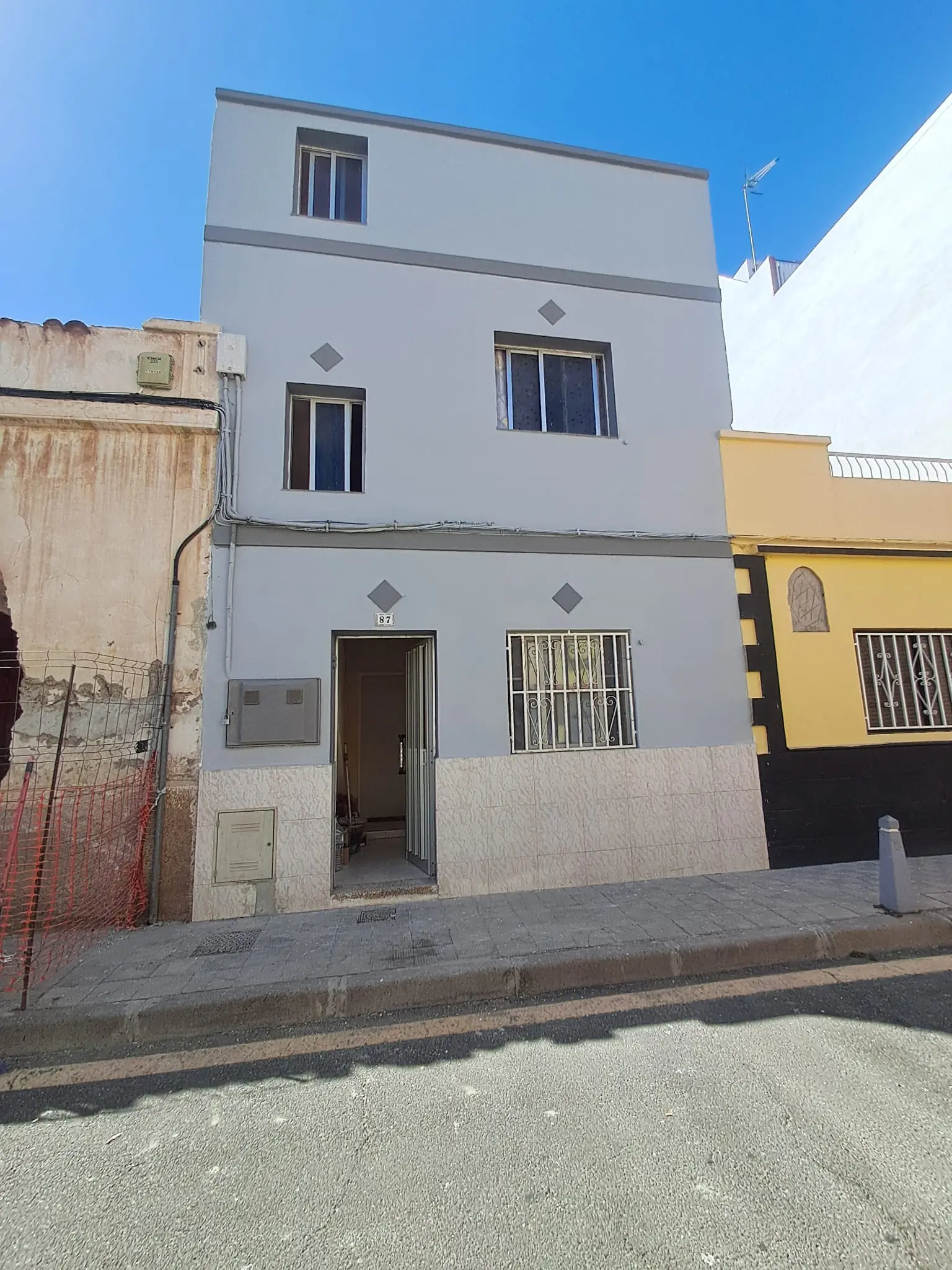 La misma fachada después, reparada y pintada en gris