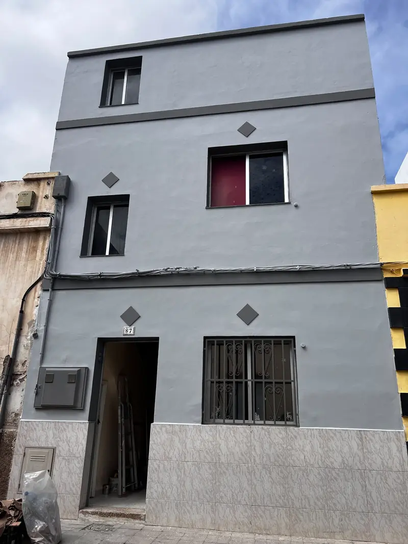 Fachada de una casa pintada en gris al terminar la obra